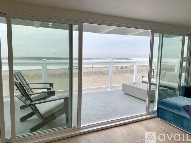 A balcony with a chair and a view of the beach.