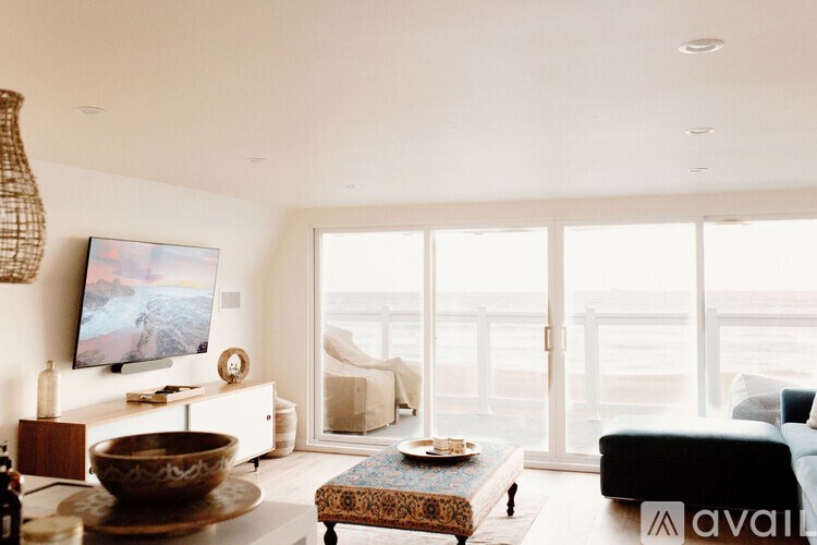 A living room with a flat screen TV, a sofa, and a coffee table.