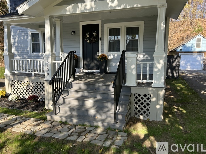 A house with a blue door and a black railing.