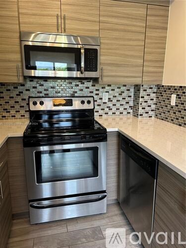 A modern kitchen with a stove and microwave above it.