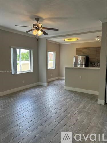 A room with a ceiling fan and tile flooring.