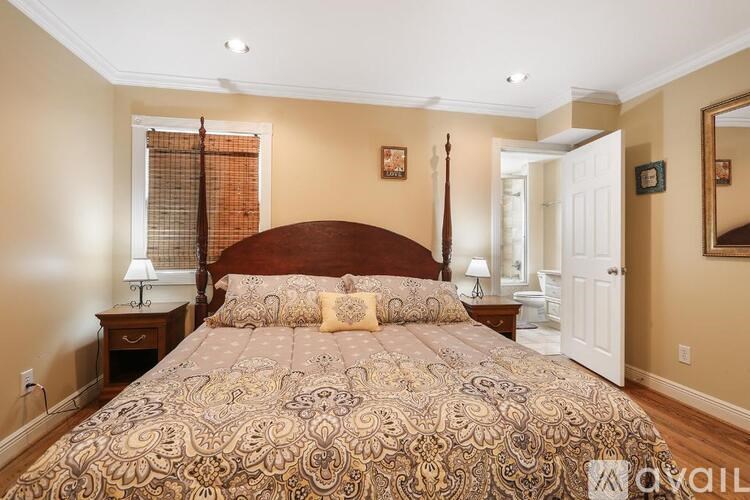 A bedroom with a large bed and a mirror on the wall.