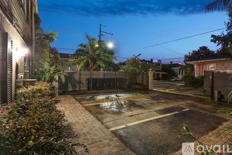 A backyard with a fence and a lit pathway.