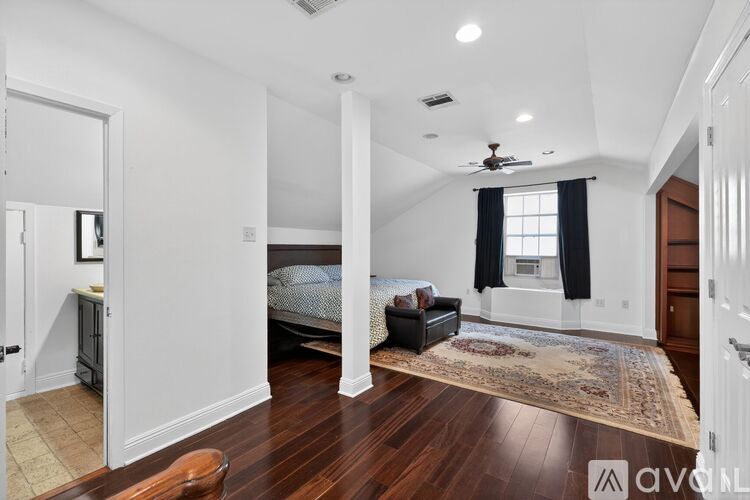 A bedroom with a large bed and a chandelier.