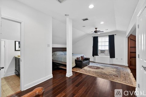 A bedroom with a large bed and a chandelier.