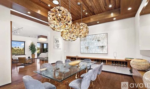 A modern dining room with a glass table and chairs.