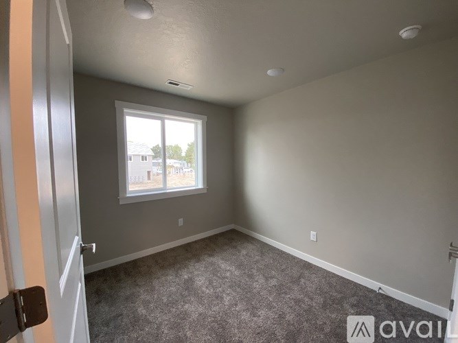 A room with a carpeted floor and a window.