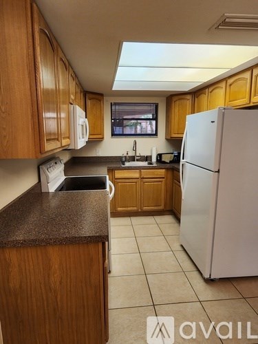 A kitchen with wooden cabinets and a white refrigerator.