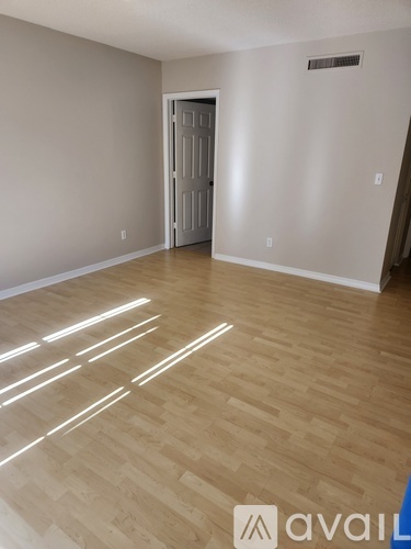 A room with wooden flooring and a white door.