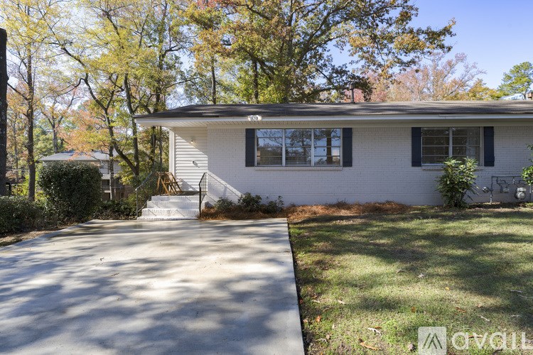 A house with a driveway and trees in the background.