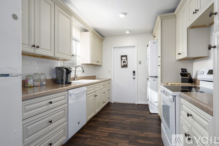 A kitchen with white appliances and wooden cabinets.