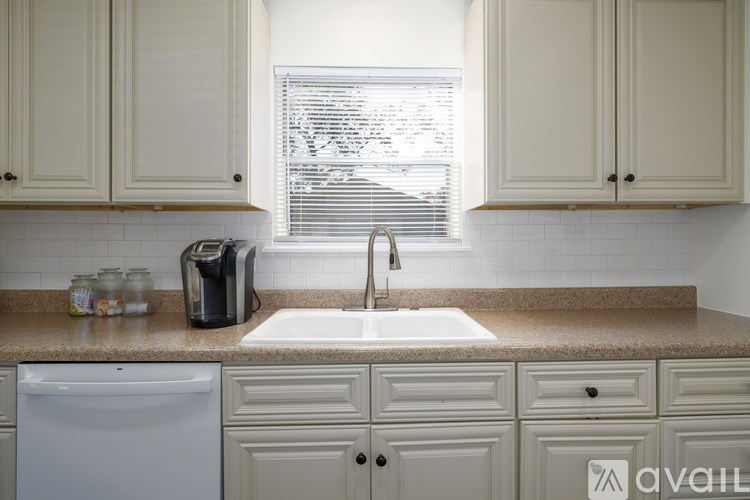 A kitchen with a white dishwasher and a sink.