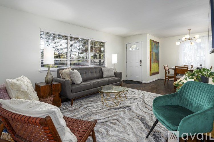 A living room with a grey sofa, a green armchair, and a wooden coffee table.