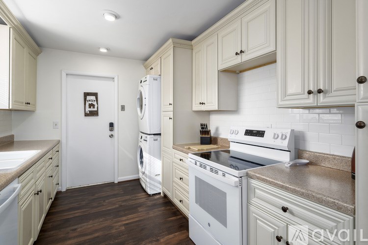A kitchen with white appliances and wooden cabinets.