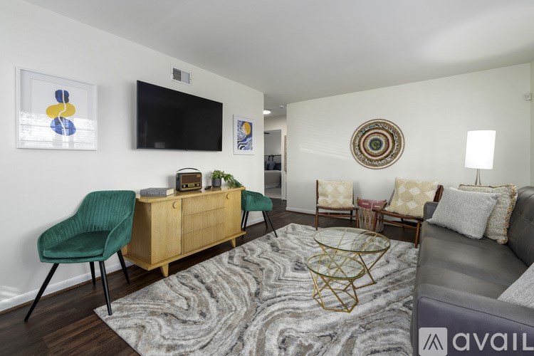 A living room with a green chair and a wooden cabinet.