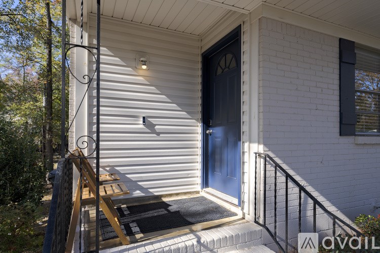 A house with a blue door and a black railing.