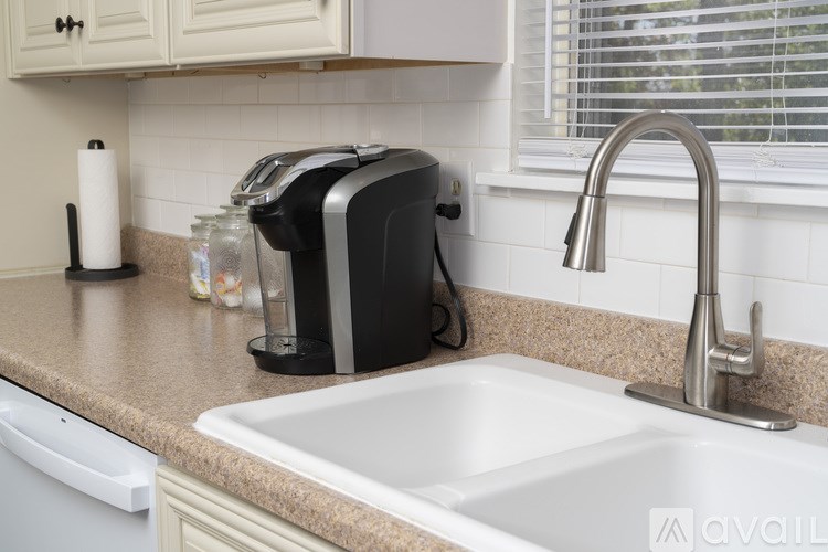A kitchen with a sink, a toaster, and a window.