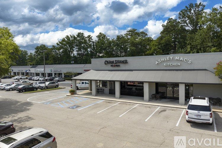 A parking lot with a building that has a sign that says Ashley Mac's Kitchen.