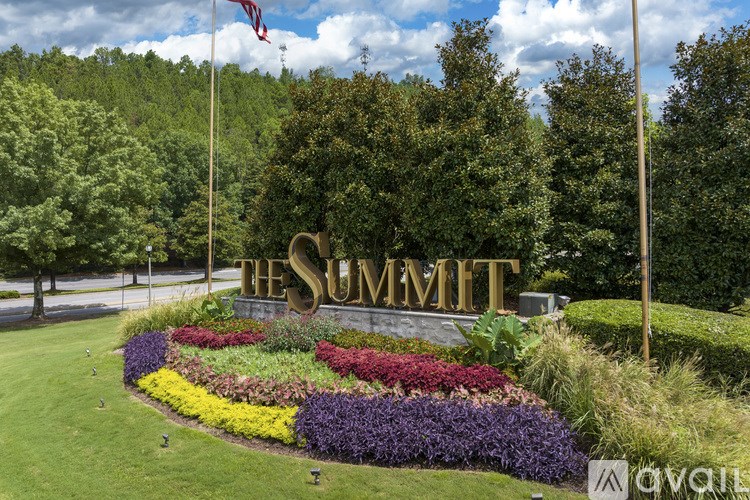 The Summit sign is displayed in front of a flower bed.