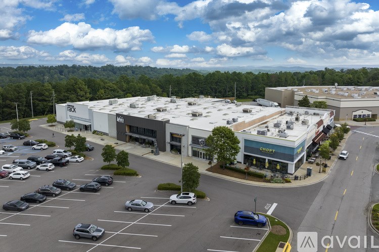 A parking lot with cars and a building with a sign that says "Shoe" in front of it.