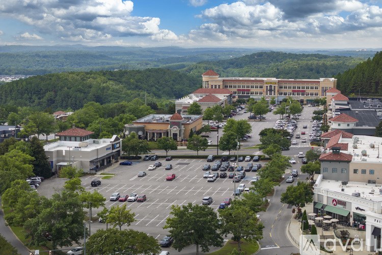 A parking lot with cars and a large building in the background.