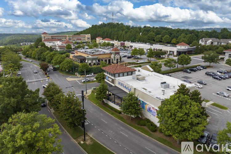 A view of a road with cars and a building with a sign that says "avail" on it.