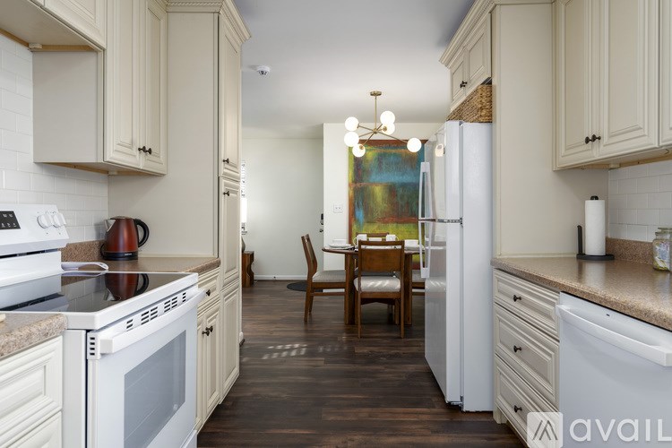 A kitchen with white appliances and wooden cabinets.
