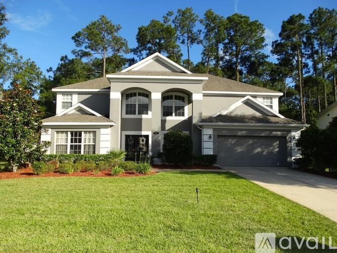 A large house with a grey roof and a white garage door.