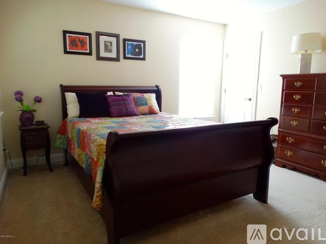 A bedroom with a large bed and a dresser.