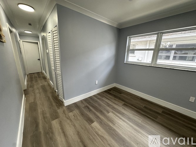 A long hallway with wood floors and white walls.