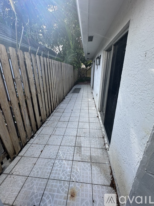 A tiled walkway leads to a door on the right.