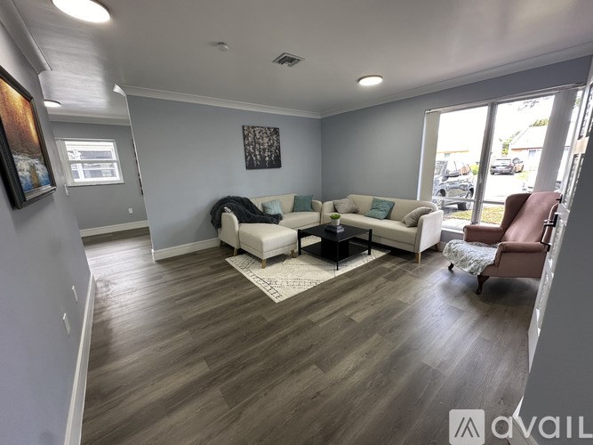 A living room with a white couch and a brown chair.
