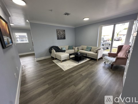 A living room with a white couch and a brown chair.