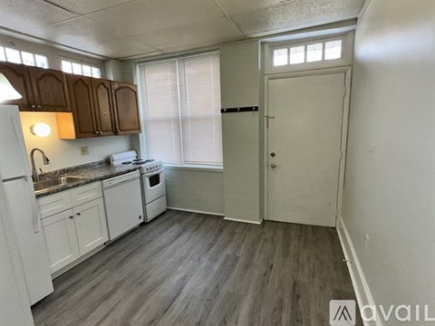 A kitchen with white appliances and wooden cabinets.