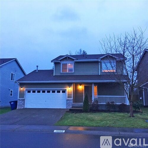 A house with a garage and a driveway in front of it.