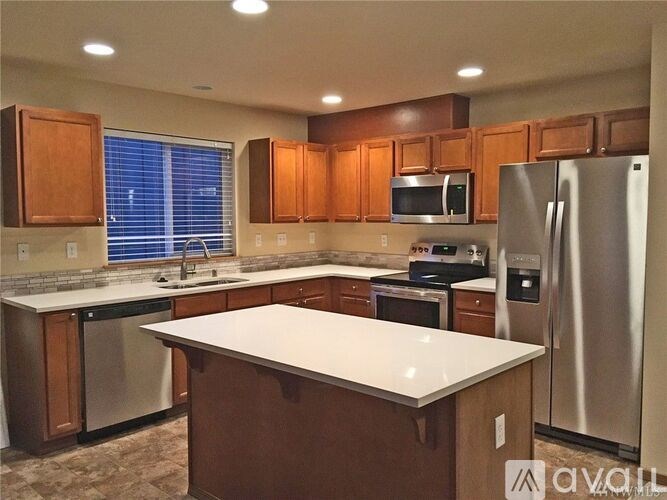 A kitchen with wooden cabinets and stainless steel appliances.