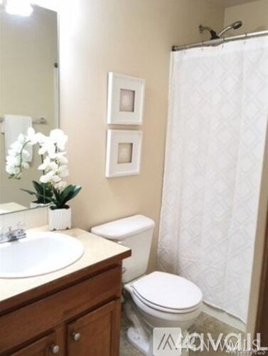 A white toilet sits next to a white sink in a bathroom.