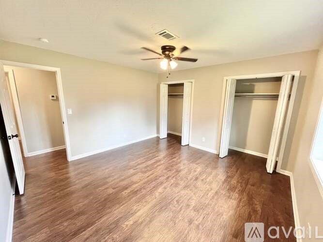 A room with wooden flooring and a ceiling fan.