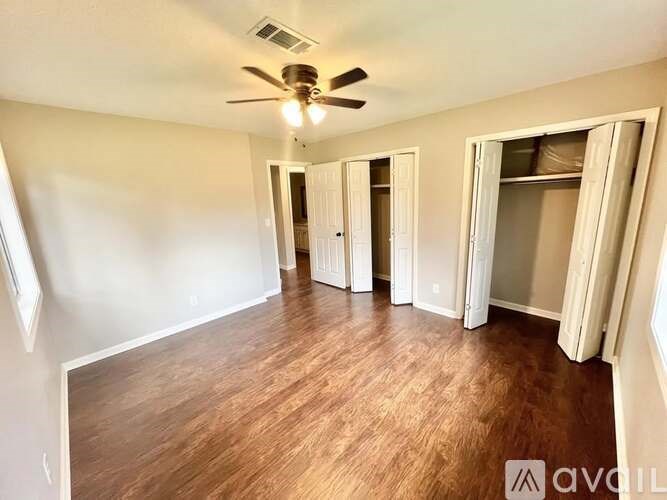 A room with wood flooring and a ceiling fan.