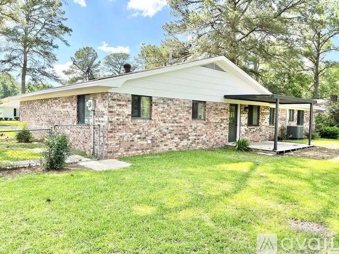 A house with a stone wall and a white roof.