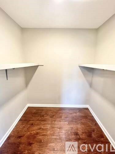 A room with wooden flooring and white walls.