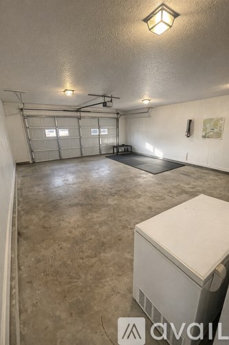 A spacious garage with a white cabinet and a ceiling light.