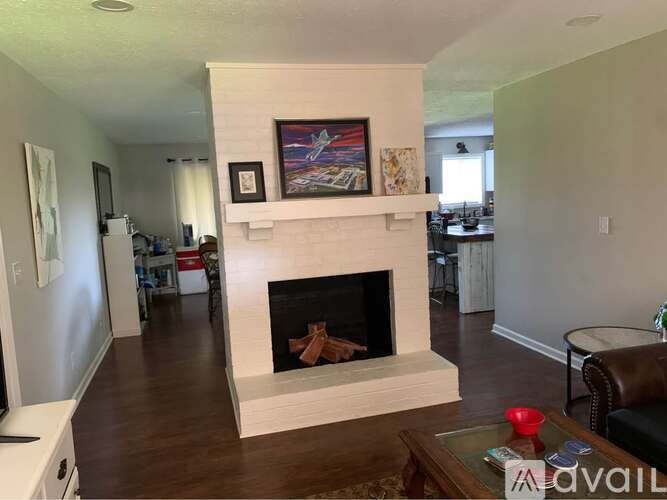 A living room with a fireplace and a painting above it.