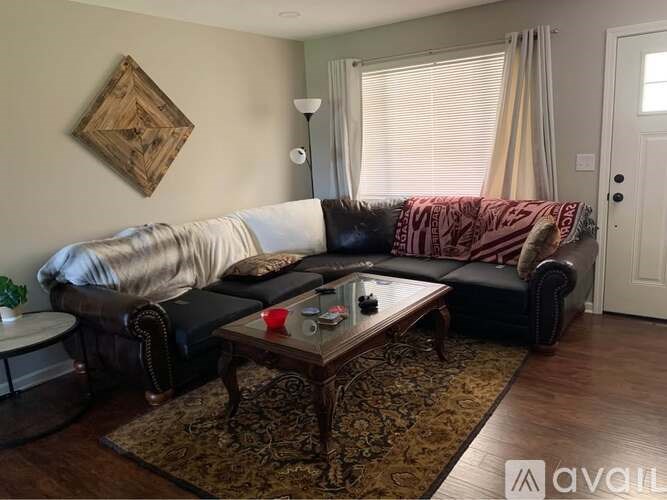 A living room with a black couch and a coffee table.