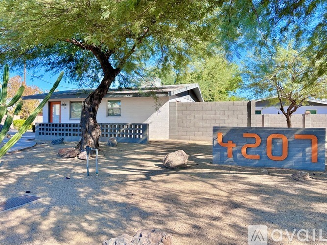 A house with a blue sign that reads "4207" in front of it.