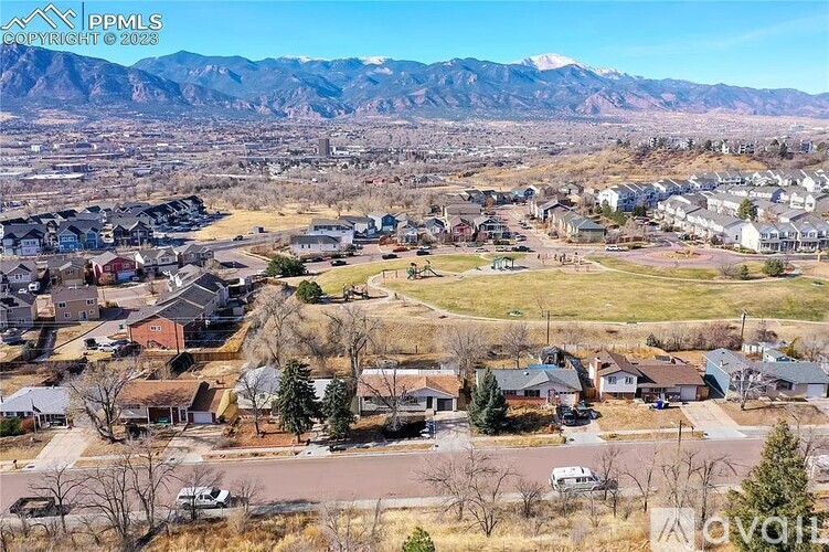 A suburban neighborhood with houses and a mountain range in the background.