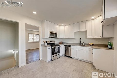 A kitchen with white cabinets and appliances is available for rent.