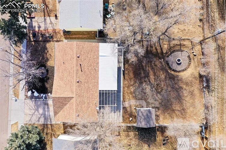 A bird's eye view of a building with a circular window and a tree in the foreground.