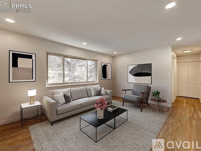 A living room with a grey sofa, a black coffee table, and a grey armchair.