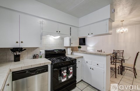 A kitchen with white cabinets and a black stove top oven.